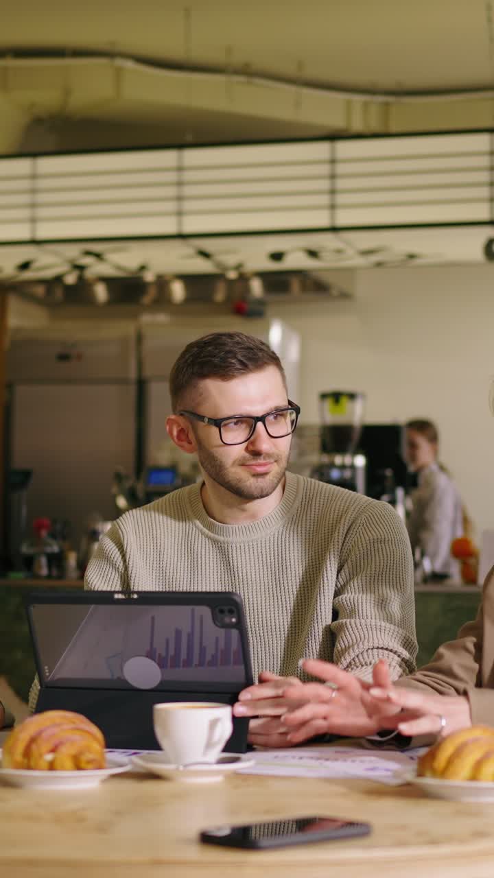 Business People Discussing Data and Strategy in a Cafe