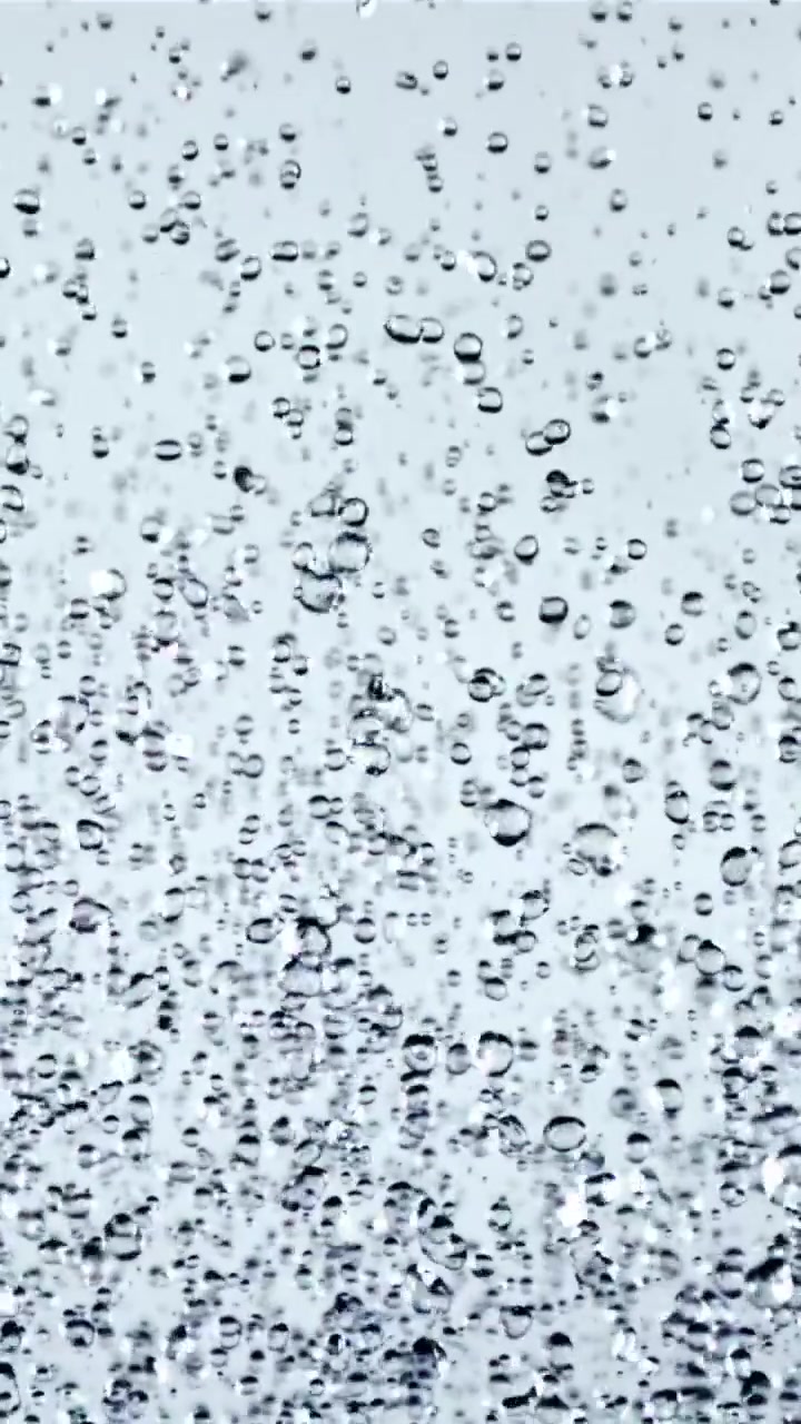 Primo piano al rallentatore di gocce d'acqua limpida che cadono