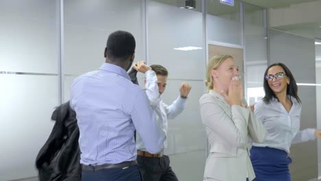 happy business team celebrating in office corridor