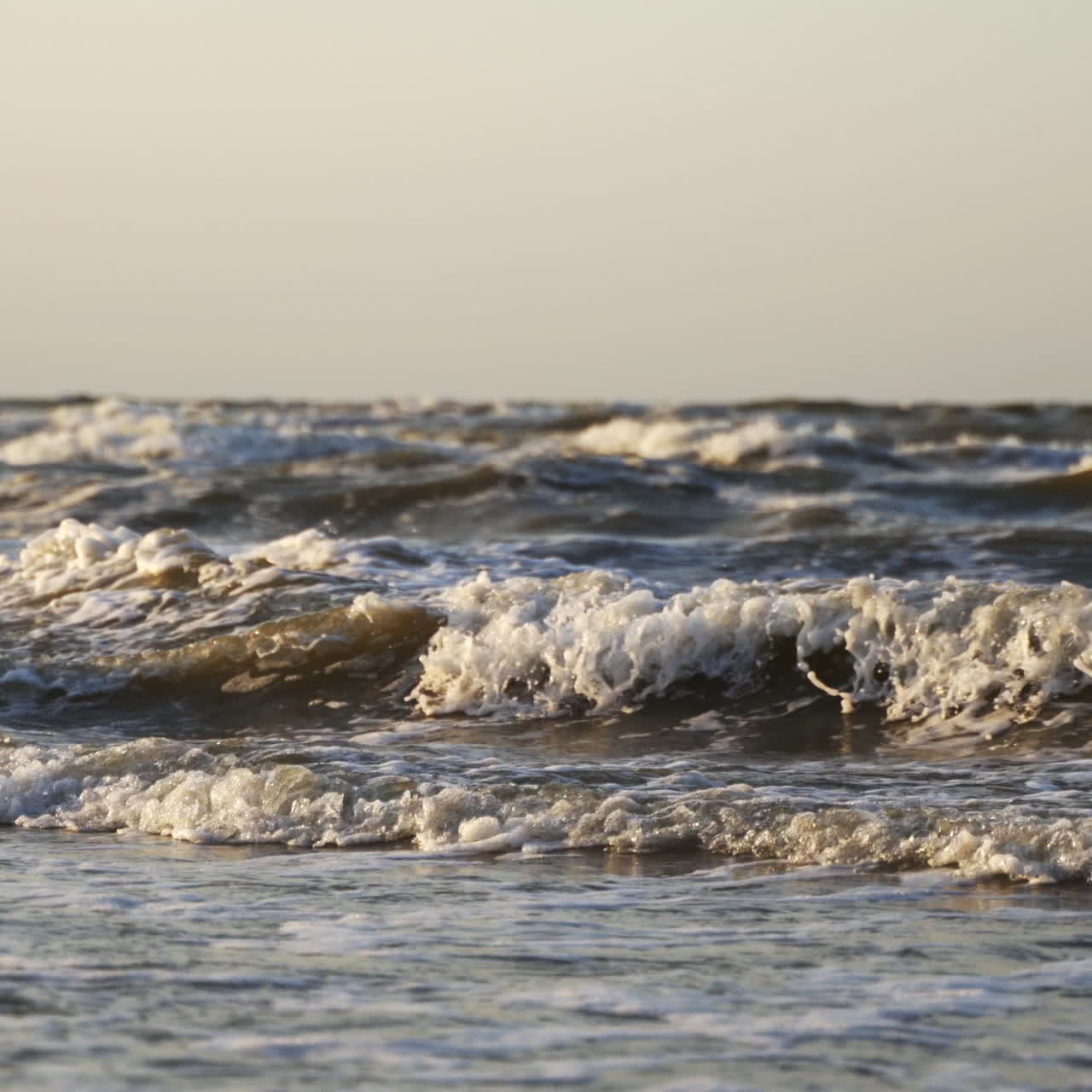 Storm in the sea. Big foamy waves crashing on the beach. Oceanic background at the edge of a coastline. Close-up.