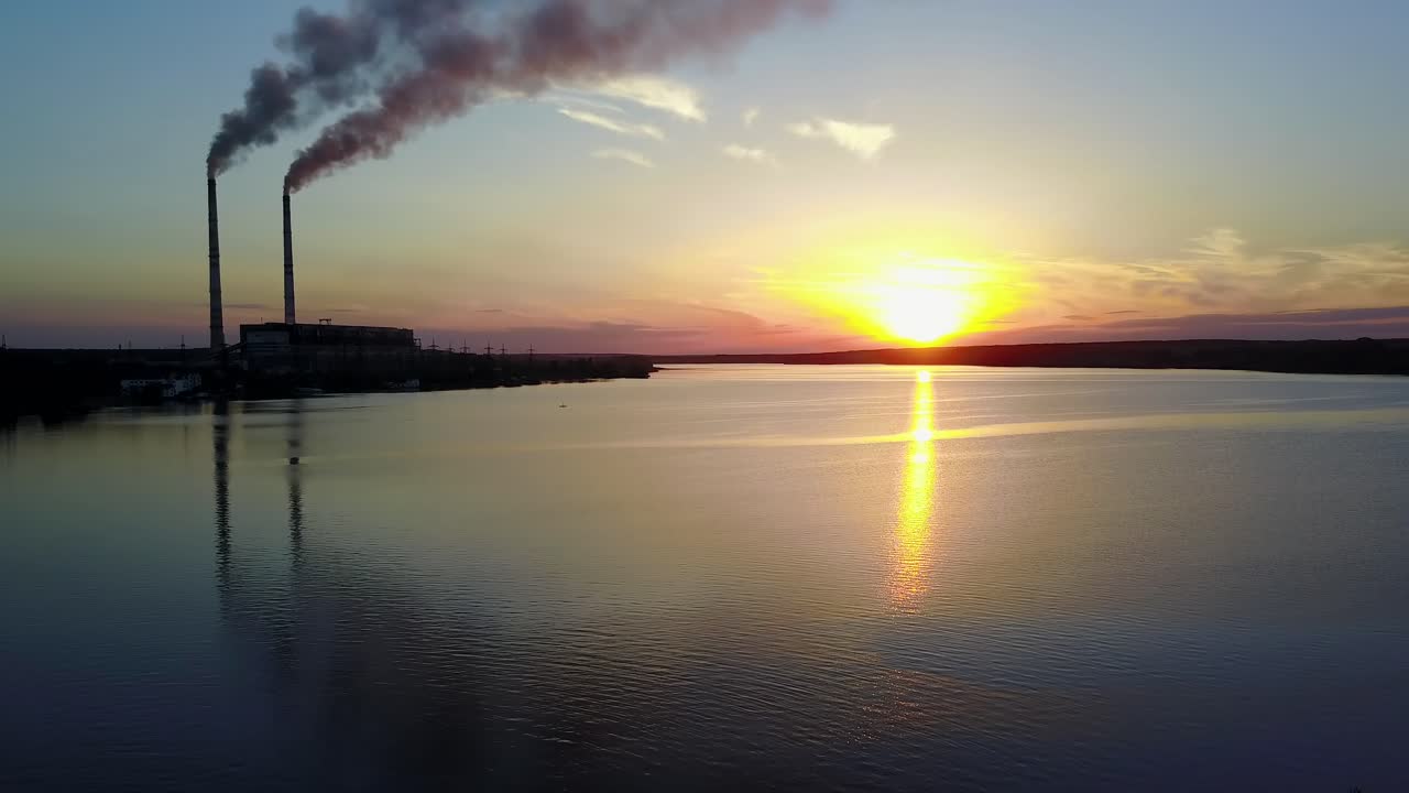 Pipe with smoke near people which spend time near river