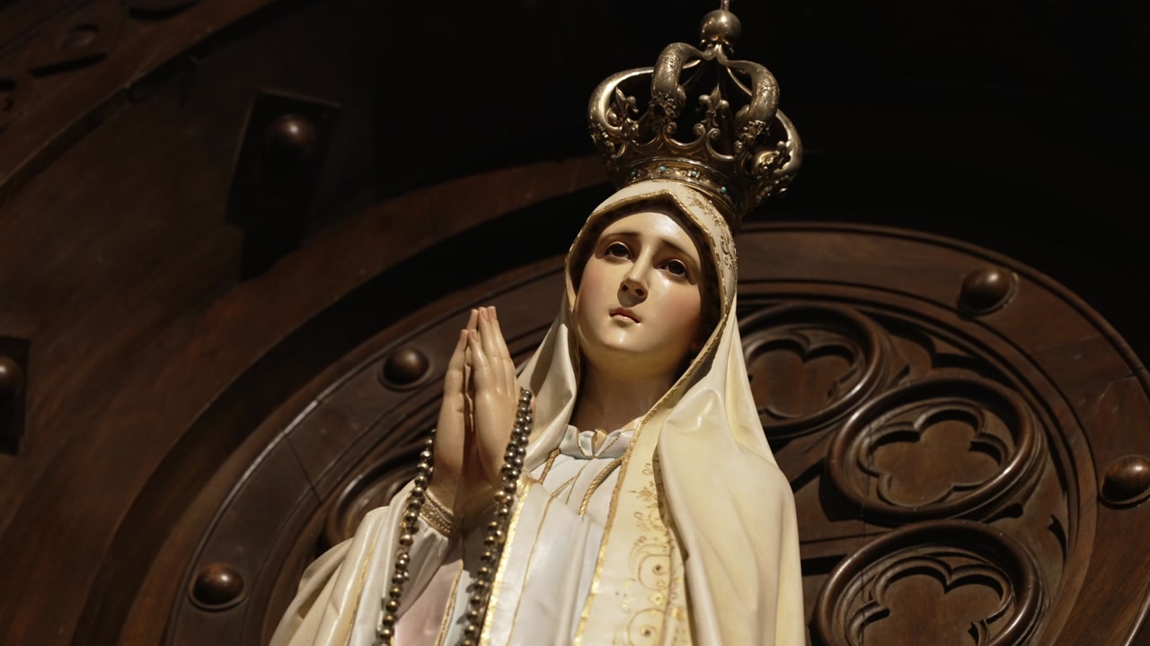 Close up of Our Lady of Fatima statue with crown and rosary in church