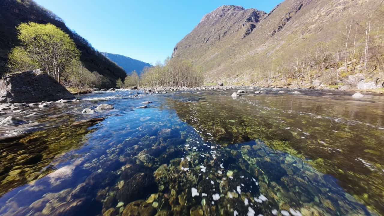 Dramatic Low Flying Above Crystal Clear River Water in Highlands or Norway