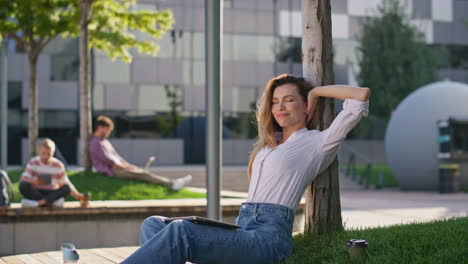 chica independiente estirando las manos en el parque de la ciudad. mujer de negocios remota terminar el trabajo