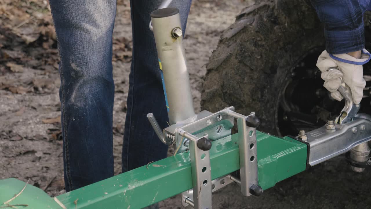 мужчина устанавливает буксировочный крюк на свой квадроцикл