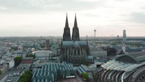 Drohne-Bewegt-Sich-In-Zeitlupe-Episch-Auf-Den-Kölner-Dom-Zu,-Sie-Kommt-Dem-Kölner-Dom-Sehr-Nahe-Und-Man-Sieht-Die-Sonnenstrahlen-Durch-Die-Türme-Scheinen,-Filmisches-Intro