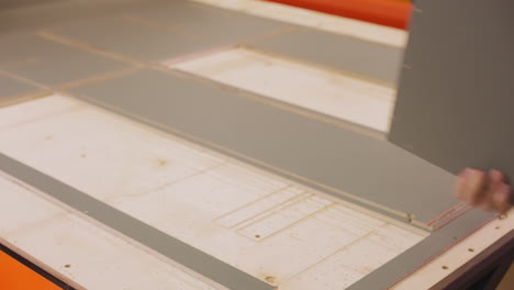 worker takes rectangle plywood detail in woodwork shop