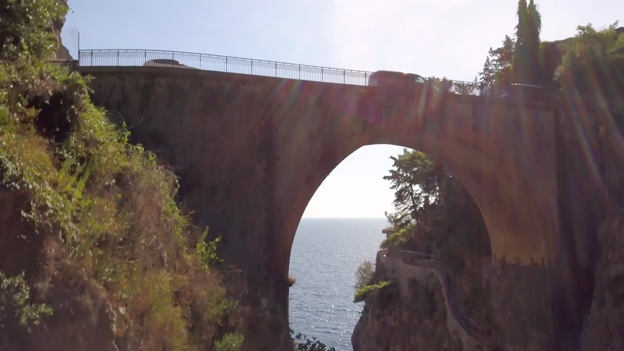 puente de arco fiordo di furore con tráfico de automóviles que pasa por encima y barcos en el océano, costa de amalfi en salerno, italia, vista superior de drones aéreos tiro giratorio