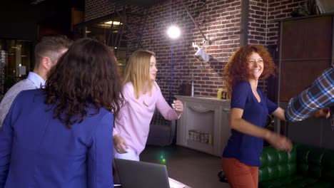 concepto de negocios, startups y personas - equipo creativo feliz con computadoras y carpetas discutiendo proyectos en un espacio compartido en el loft.