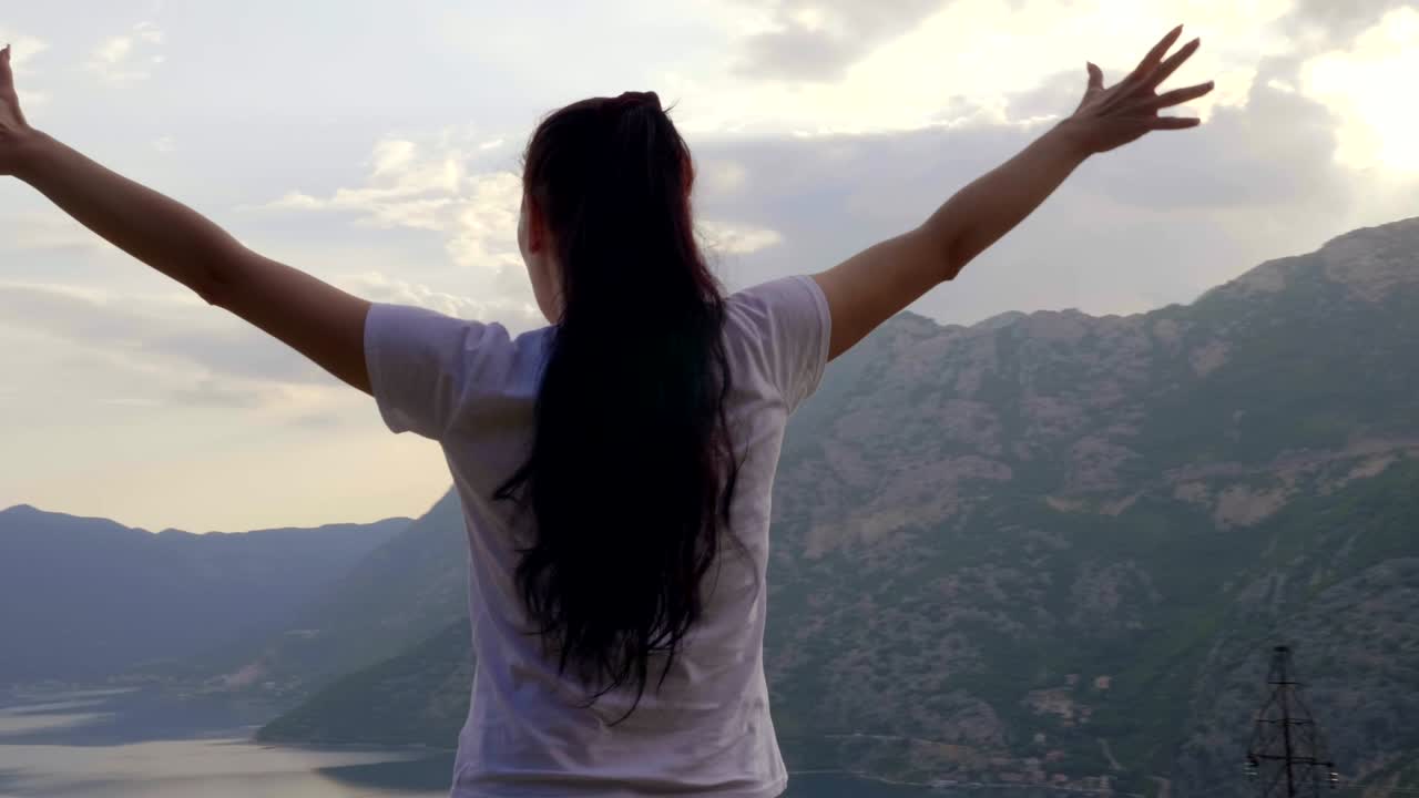 la chica grita de felicidad en la cima de la montaña
