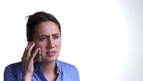 Studio-Shot-Of-Angry-Young-Woman-Talking-On-Mobile-Phone