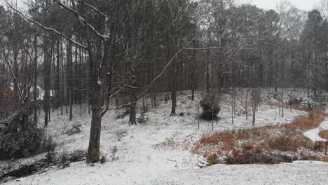 drone at low altitude flying slowly through the snow over a snow covered backyard