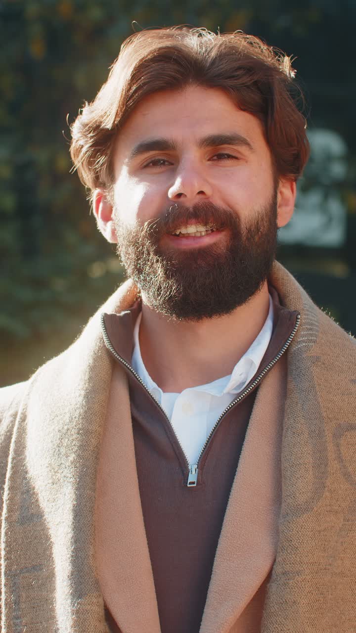 Ritratto di uomo indiano felice e sorridente che guarda in camera, con un'espressione rilassata e soddisfatta, in una strada del centro