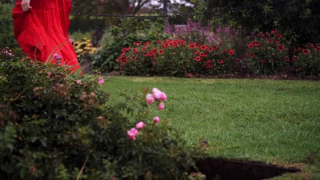 a woman in long dress walking through the grass lawn in barefoot