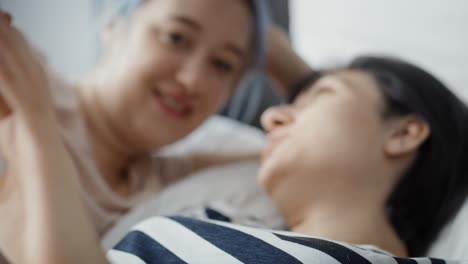 Close-up-video-of-lesbian-couple-holding-hands-in-the-bed.