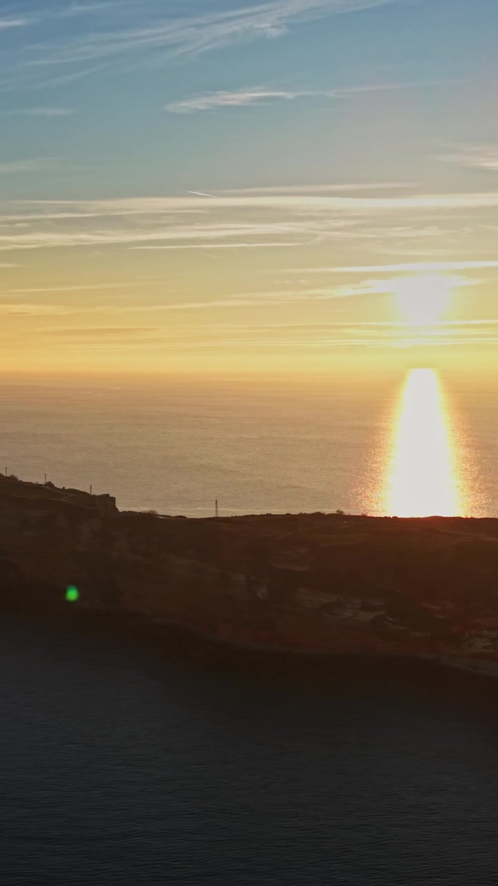 Sunset over the ocean reflecting off the cliffside at the coast