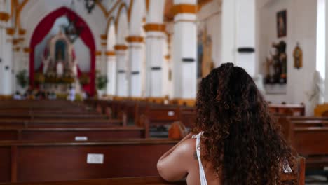 mujer orando por un milagro en la iglesia