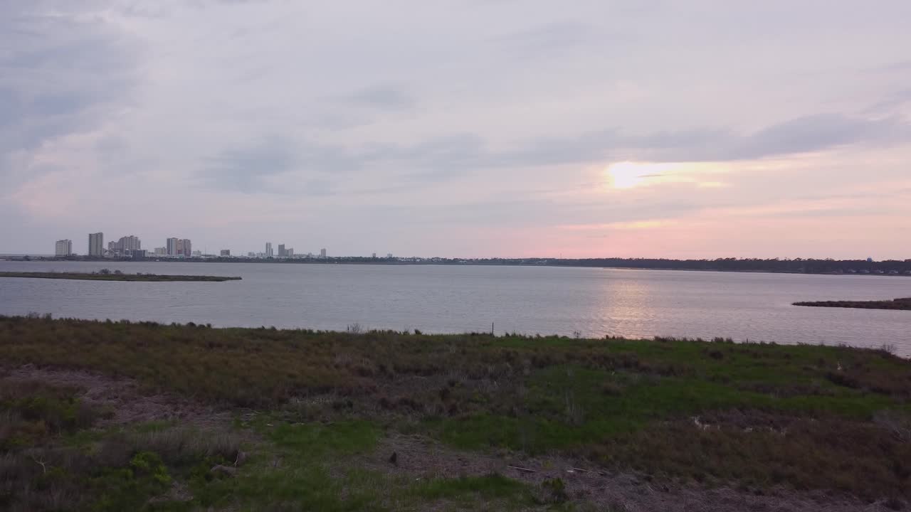 Orange Beach Alabama skyline along coastline and marshland during sunset.