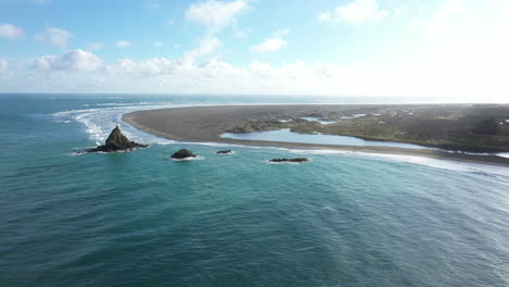 Landscape-of-Whatipu-beach-with-Ninepin-Rock-and-lighthouse,-Huia-Reserve,-NZ