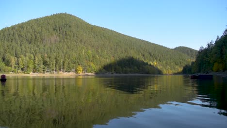 relaxing view of a big lake with reflection on the water and hills in the background in autumn