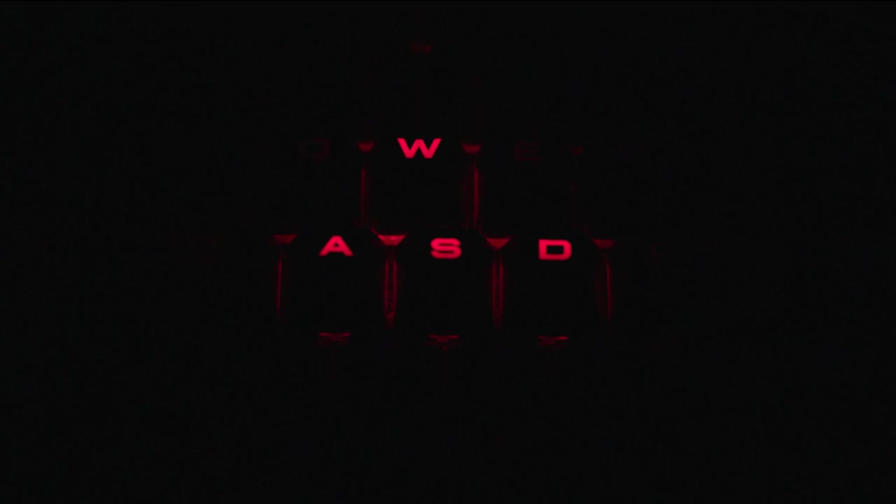 Backlit illuminated wasd keys on a gaming keyboard in a close up zoom in motion