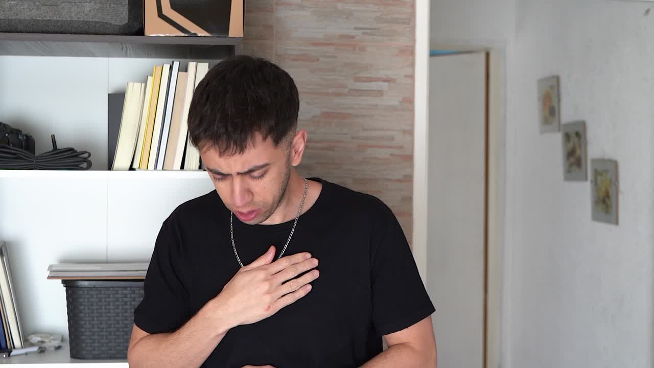 joven en casa sintiéndose mal y sufriendo de una aparente tos en el pecho