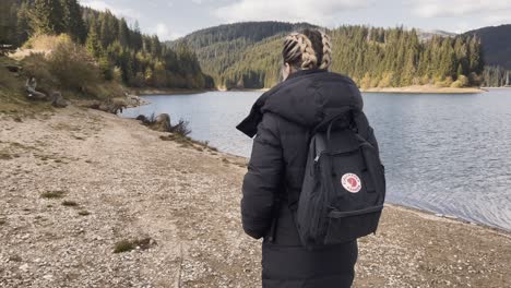 a girl with a backpack near bolboci lake in romania