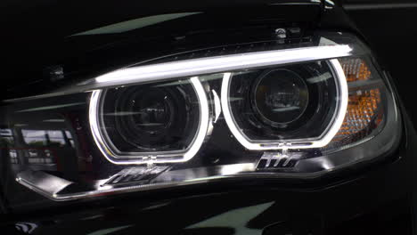 close-up of a car headlight turning on and then adjusting the aim of the light.