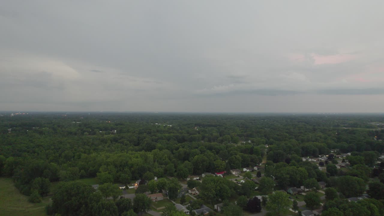 toma aérea de drones inclinados hacia arriba de pequeñas casas de pueblo conectadas por la red de carreteras durante la noche