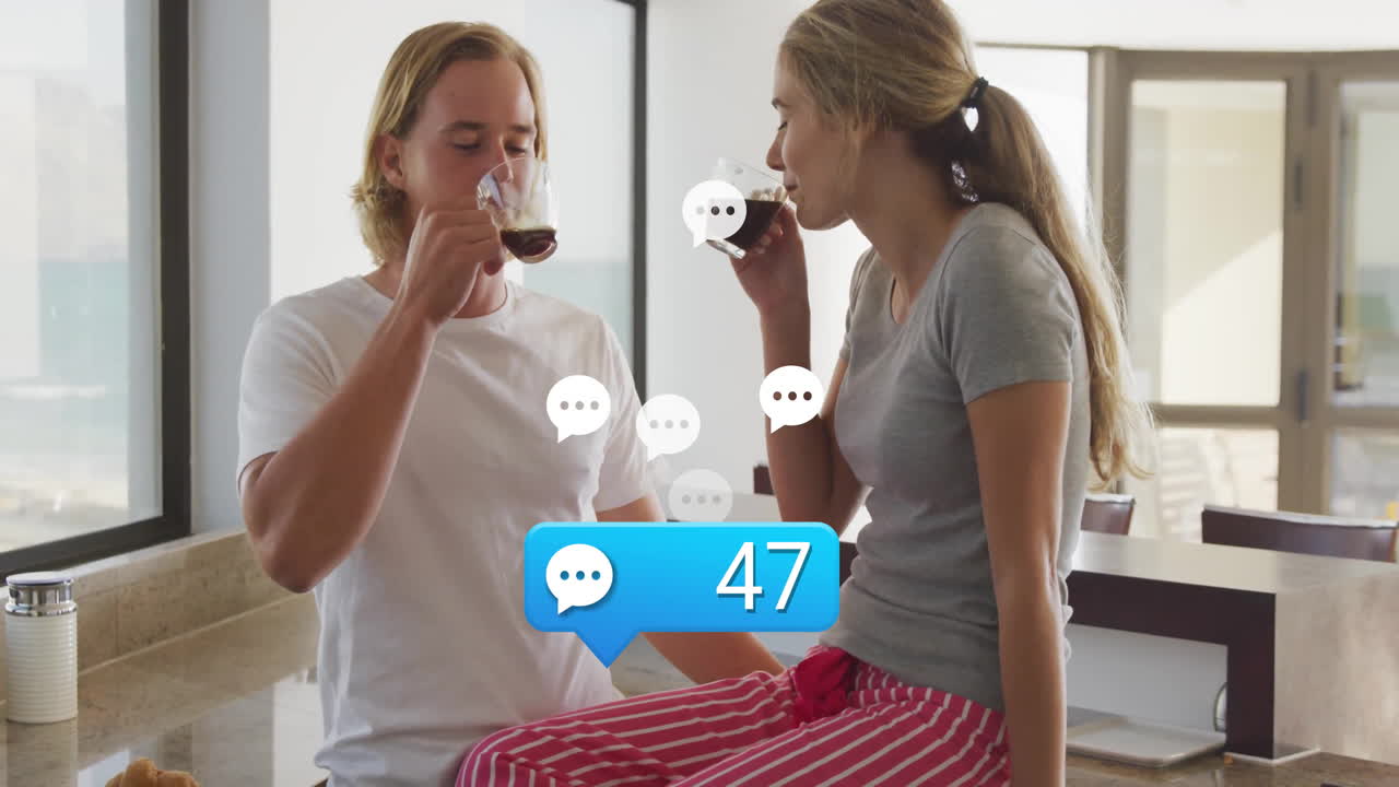 Couple sipping coffee at kitchen counter, showing chat icons and technology notification