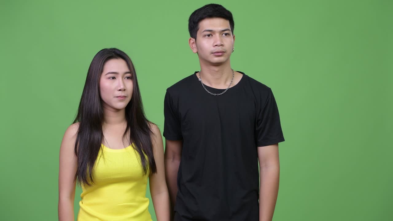 젊은 아시아 커플이 손가락으로 서로를 가리키고