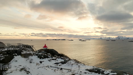 Scenic-golden-sunrise-arctic-seascape-view-with-snowy-mountains,-Henningsvaer-drone