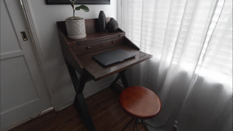 modern, clean home office with decor, plants, mirror and closed laptop on desk