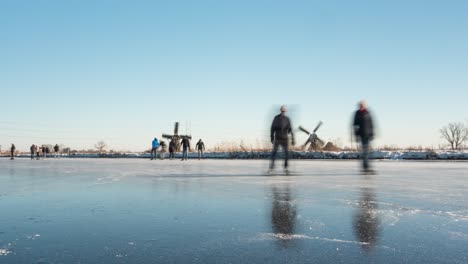 time lapse of people ice skating on frozen canal in netherlands, winter scenery