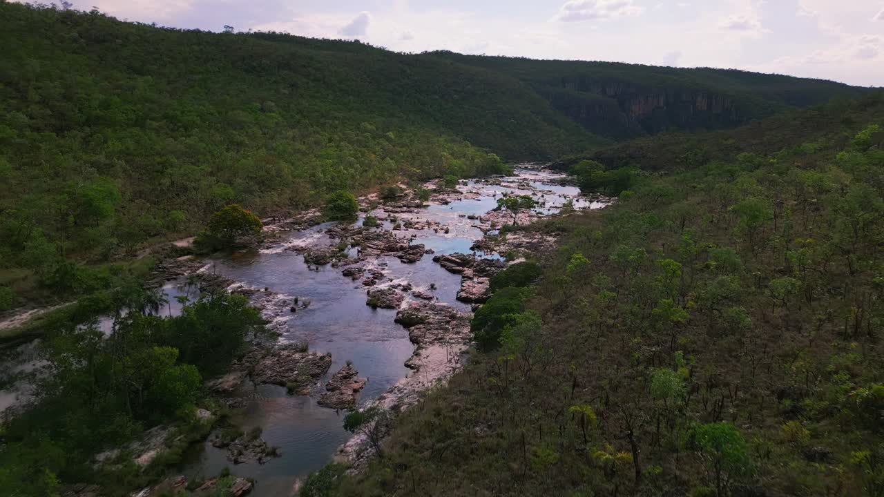 cataratas do couros cascada por una ladera rocosa, rodeada de vegetación en el parque nacional de chapada dos veadeiros, brasil, creando un paisaje natural impresionante.