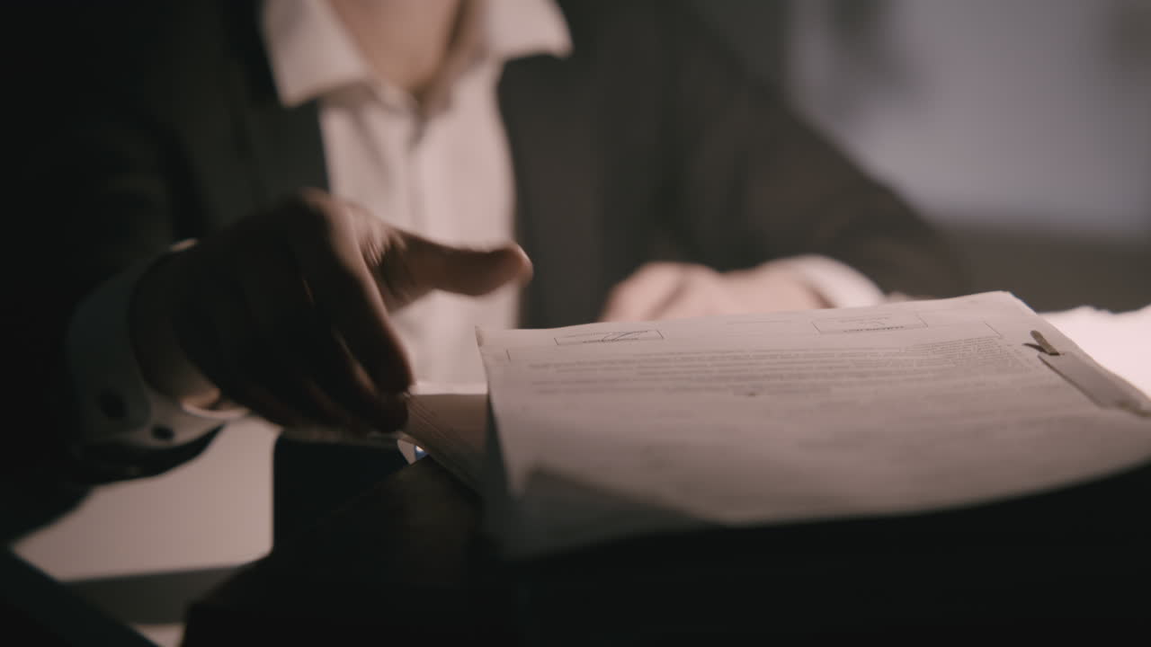 Pale bald accountant looks through the tax papers in the weird room at night