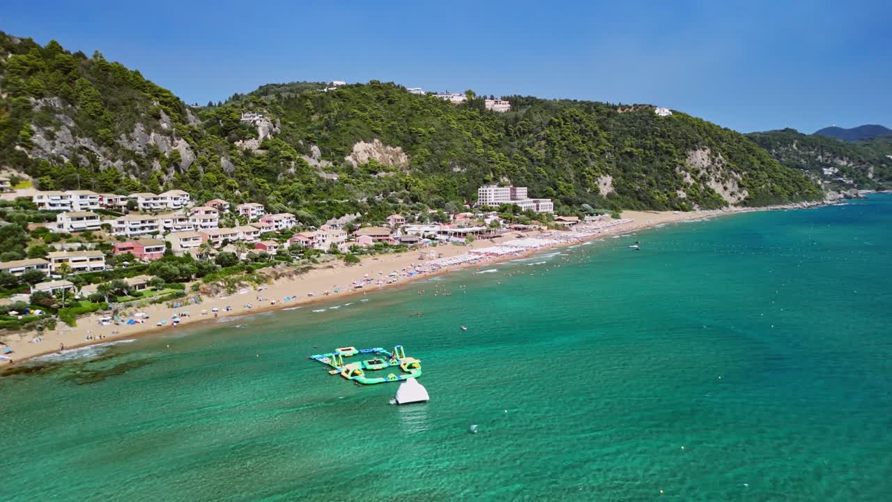 Sunny beach with clear water and distant hills in a tranquil setting