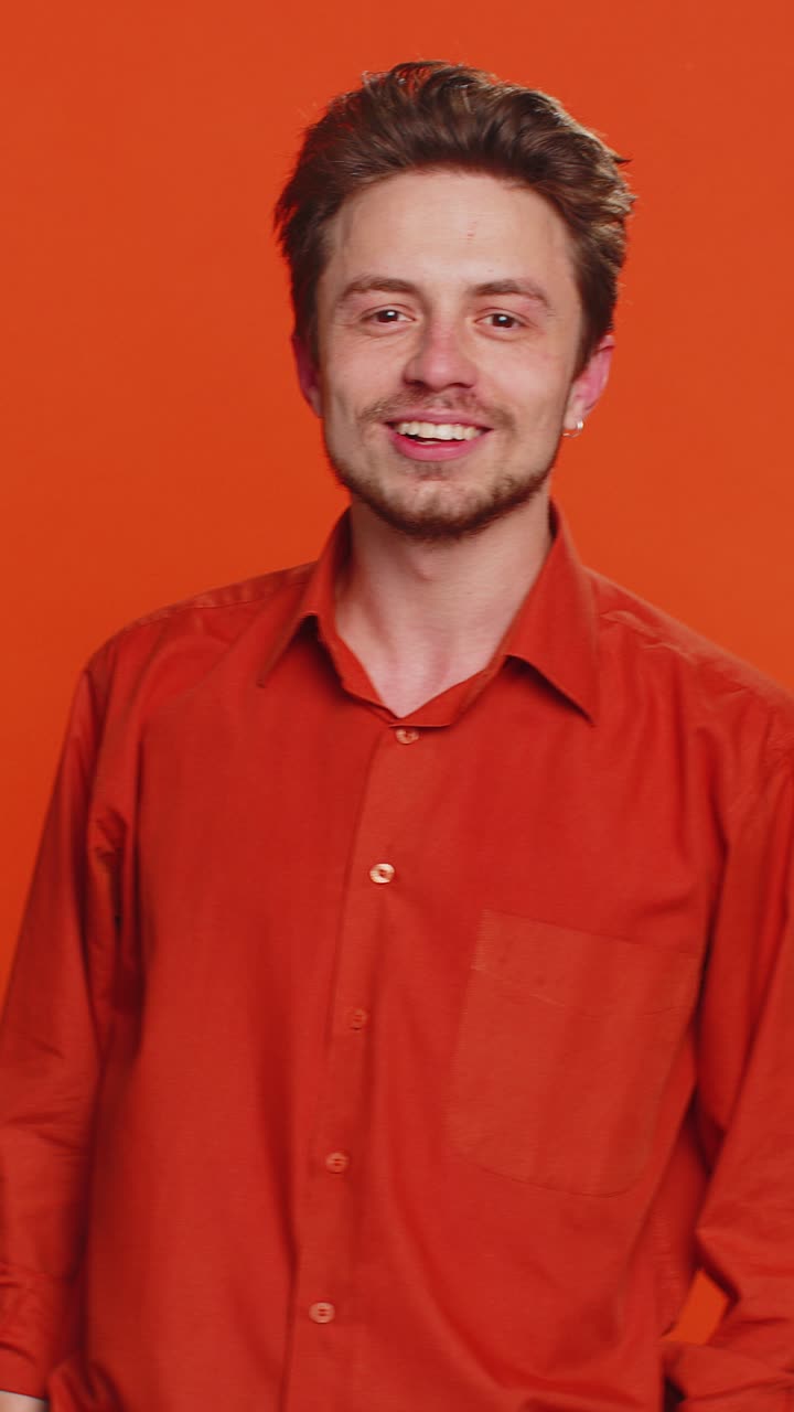 Funny bully caucasian young man showing tongue making silly faces fooling around joking teasing