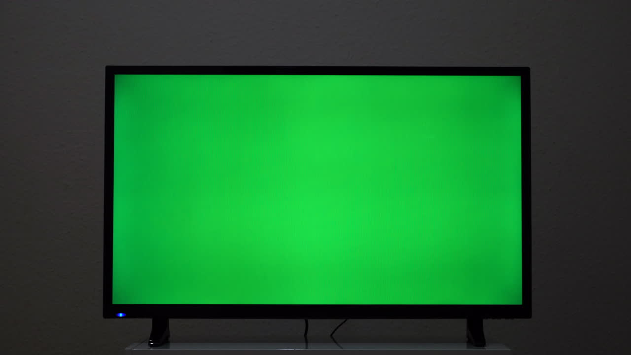 tv de pantalla verde en una habitación por la noche
