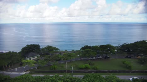 Flying-away-from-ocean-side-car-rest-area-on-moderately-cloudy-day