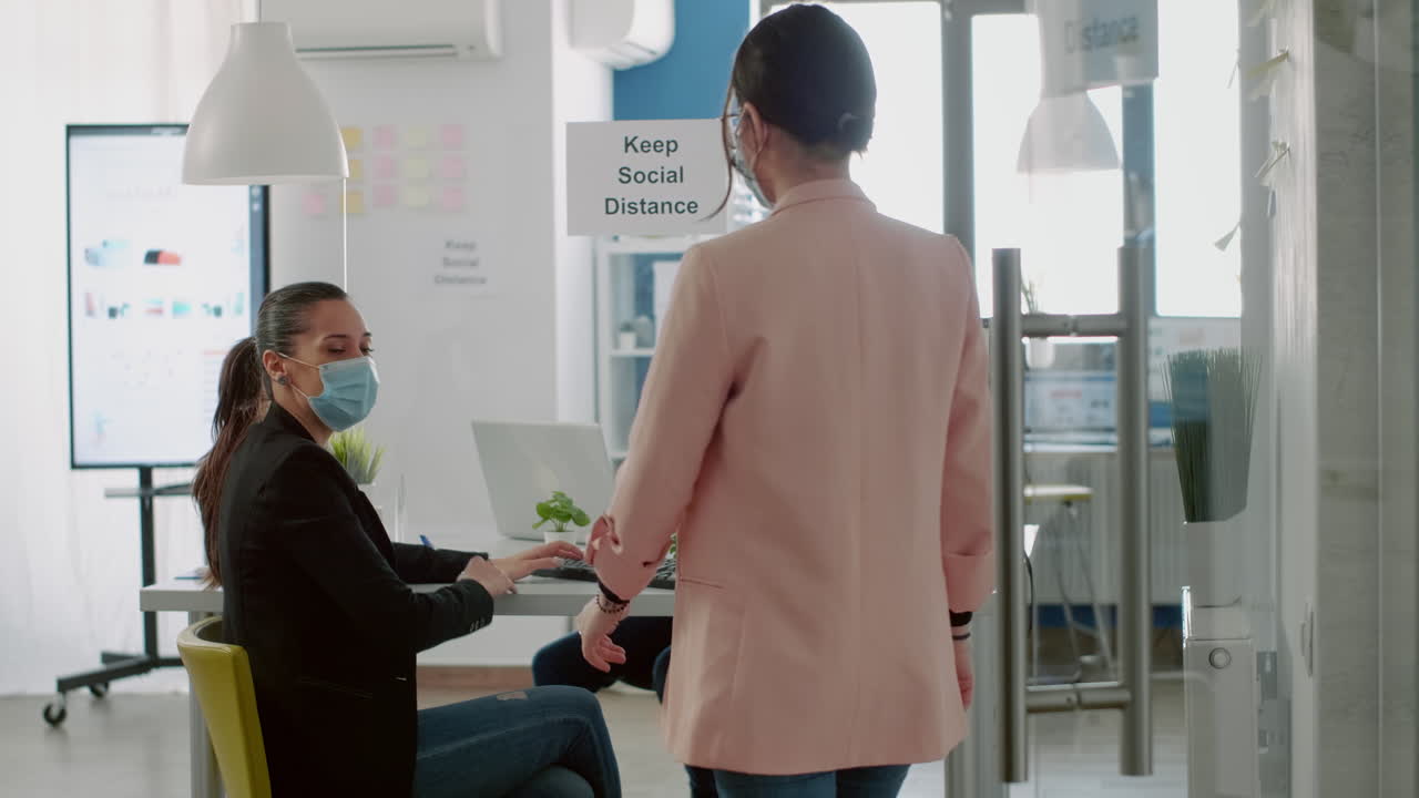 사업가 여성이 사회적 거리를 존중하기 위해 팔꿈치를 만지고 있습니다.