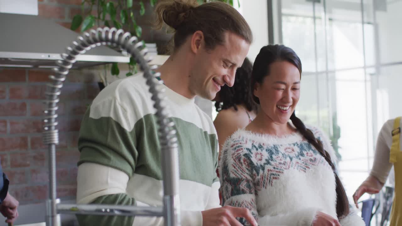 다양한 여성과 남성 친구들의 행복한 그룹이 부 ⁇ 에서 함께 요리하고 있습니다.