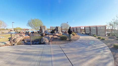red haired male photographing mandarin duck at mansel crater park in queen creek arizona.