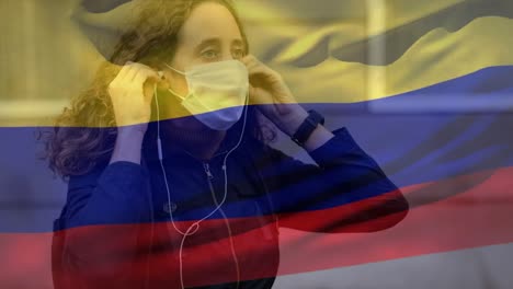 bandera colombiana ondeando contra una mujer con máscara facial