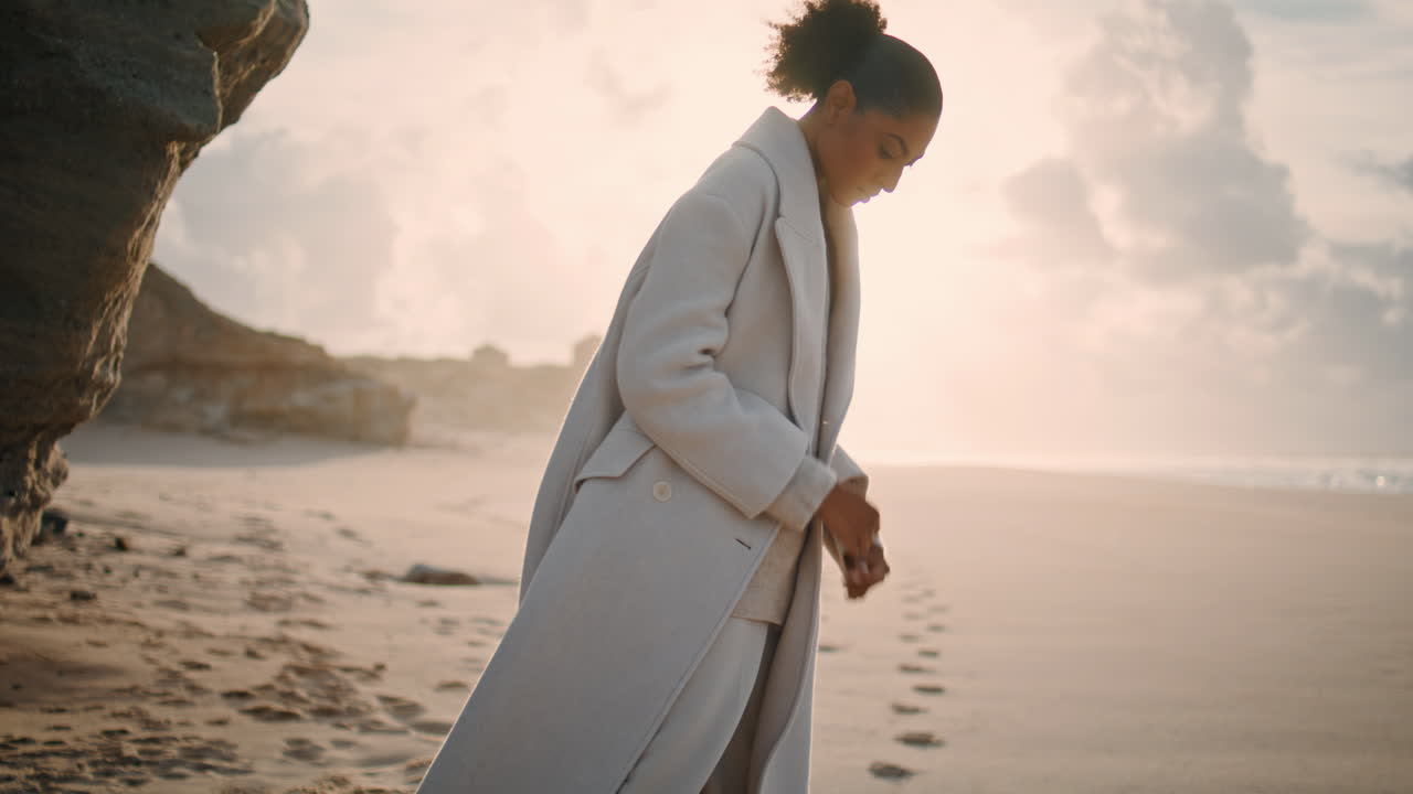 Serene woman resting beach play with sand in sunlight. Black hair tourist enjoy