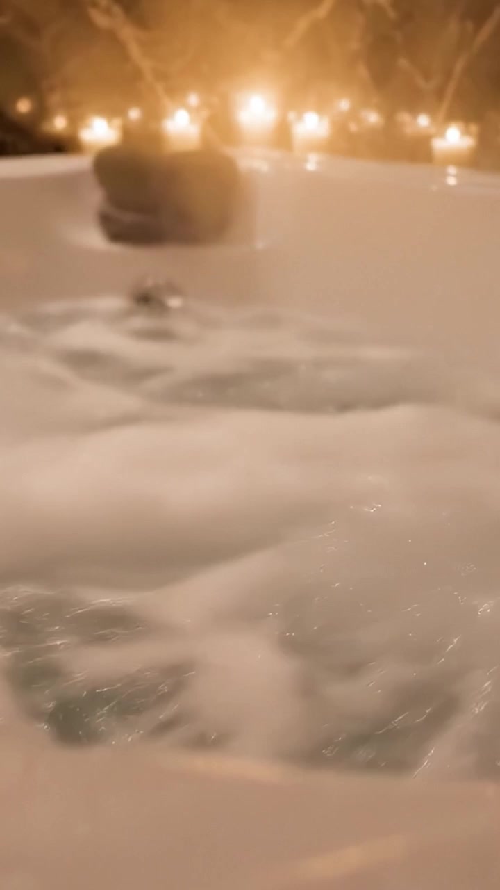 Relaxing Bubble Bath Experience with Soft Lighting and Surrounding Candles for a Cozy, Spa-Like Atmosphere