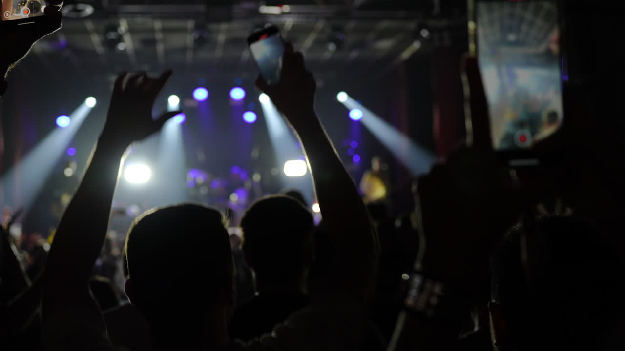 Silhouette of man cheering at concert