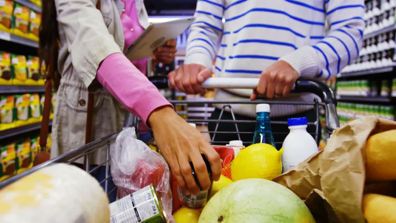 쇼핑 할 때 디지털 태블릿을 사용하는 커플