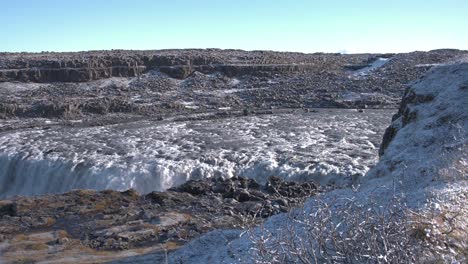 Enormes-Cascadas-Del-Río-Dettifoss-En-Islandia-En-Un-Valle-Rocoso,-Soleado