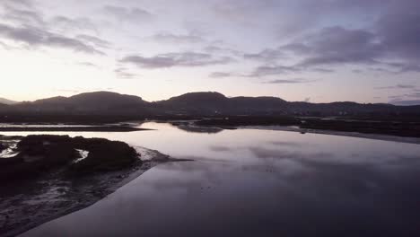 Reflexiones-De-Nubes-Al-Atardecer-En-España-Ría-De-Marea-Inundada-Paisaje-Costero-Aéreo